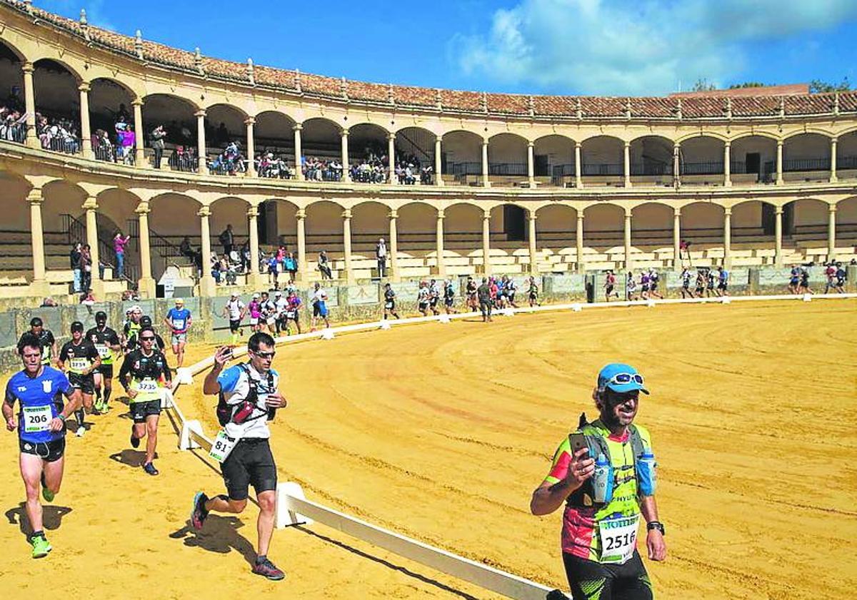 Imagen principal - From top: Runners in the Ronda 101km in the famous bullring, Ultra Sierra Nevada competitors at the ski resort and a runner in the Seville marathon passes the iconic cathedral.